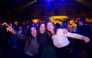 Tres amigues somrient a la festa de cap d’any de Barcelona.
